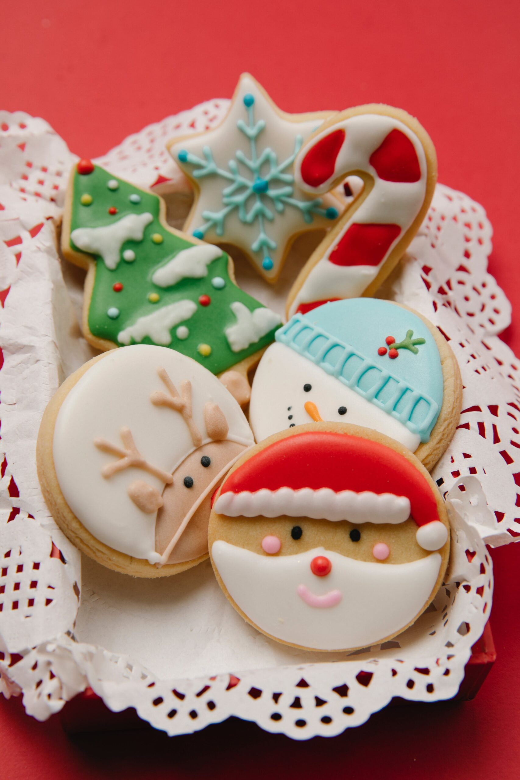 easy holiday cookies decorated with frosting to show santa claus, snowmen, and reindeer.